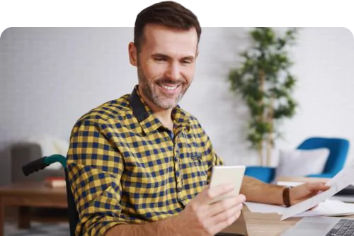 a man smiling while looking at his phone