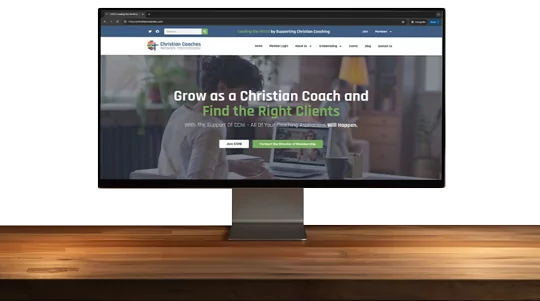 a desk with the christian coaches website shown on a computer monitor