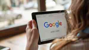 A woman holding an Ipad showing the Google Logo